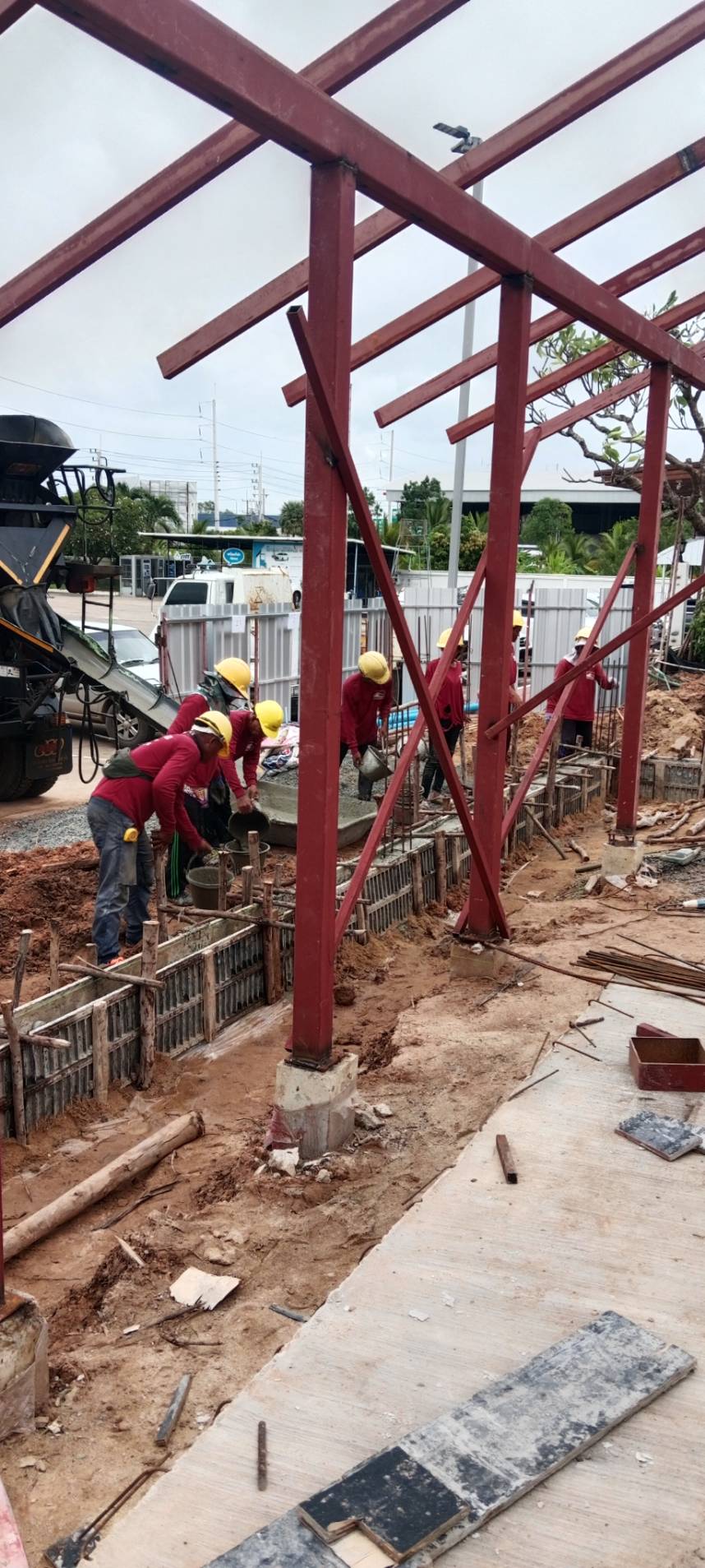 ทีมงานกำลังทำงานคอนกรีตบริเวณโครงสร้างเหล็กในหน้างานคาเฟ่